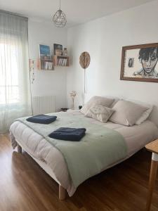 Un dormitorio con una cama grande con dos toallas encima. en Cosy Room, en Vertou