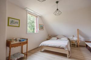 a bedroom with a bed and a desk and a window at Ti Nevez in Le Bono
