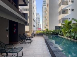 a balcony with chairs and a swimming pool in a building at Setin Pamplona - Studios por temporada in Sao Paulo
