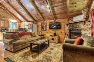 un soggiorno con 2 divani e un camino in pietra di Cozy Bear Lodge By Avada Properties a Sevierville