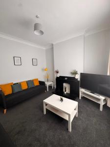 a living room with a couch and a tv at Grantham House - Sleeps 6 - Pet friendly - Parking in Newcastle upon Tyne