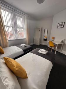 a hotel room with two beds and a desk at Grantham House - Sleeps 6 - Pet friendly - Parking in Newcastle upon Tyne