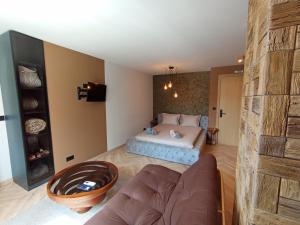 a bedroom with a bed and a couch in a room at Уютно Студио Verde Suites 07 in Blagoevgrad