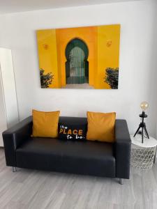 a black couch with yellow pillows in a room at Edificio Resort Gran8Nerja in Nerja