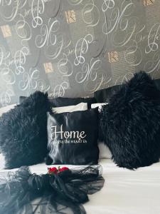 a bed with two black pillows and a wall at Couple's Getaway in Is-Swieqi