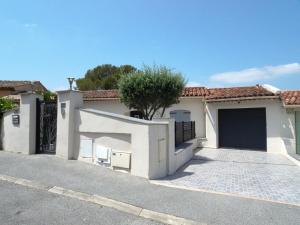ein weißes Haus mit einem Tor und einer Auffahrt in der Unterkunft Belle maison avec piscine dans les hauteurs à Saint Raphael in Saint-Raphaël