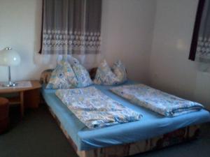 a bed with blue sheets and pillows in a room at Holiday home Cserszegtomaj - Balaton 18288 in Cserszegtomaj
