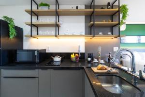 a kitchen with a sink and a microwave at Edifício Parque Jockey in Sao Paulo