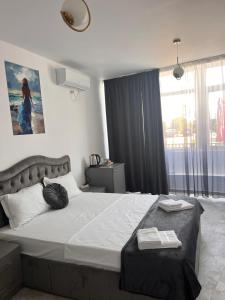 a bedroom with a large bed and a window at LA PLAYA - Camere pe plaja cu sezlong gratuit in Eforie Nord