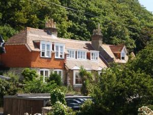 威尔汉姆Bishops Cottage Lulworth Cove的一栋房子前面停着一辆车