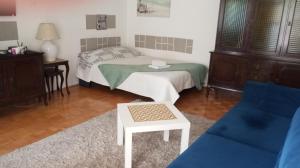 a bedroom with a bed and a table and a couch at Apartment MrC , FREE PARKING in Bežanija