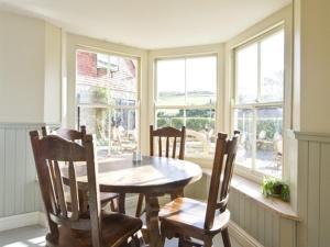威尔汉姆Bishops Cottage Lulworth Cove的一间有桌椅和窗户的餐厅