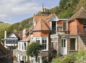 威尔汉姆Bishops Cottage Lulworth Cove的一组房子,后面有一座小山