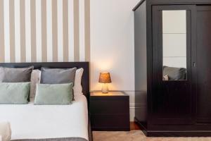 un dormitorio con una cama y un espejo en Gardenia Urban Retreat, en Oporto