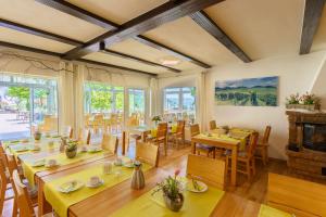 Un comedor con mesas y sillas y una chimenea. en Pension Bergterrasse, en Annweiler am Trifels