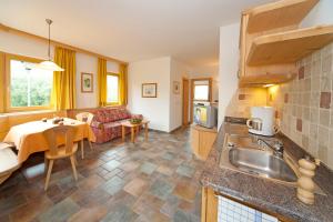 a kitchen and living room with a table and a couch at Gleifhof in Appiano sulla Strada del Vino