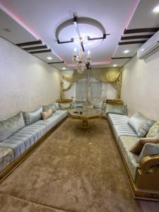 een woonkamer met een bank en een tafel bij Av des far agadir in Agadir