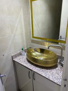 een badkamer met een gouden wastafel en een spiegel bij Av des far agadir in Agadir