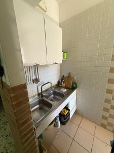 a kitchen with a sink and white cabinets at La Casetta di Nanà in Termoli