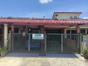 a gate in front of a house with a sign on it at Seri Homestay in Alor Setar