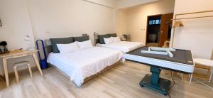 a room with two beds and a desk with a piano at 隱 Villa 旅宿 in Chaozhou