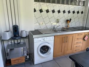 a kitchen with a washing machine and a sink at Appartement LE VERSOUD 