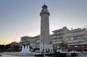 un phare devant un bâtiment avec une fontaine dans l'établissement Artemis Luxus Home and Spa Alexandroupolis City Faros, à Alexandroúpolis
