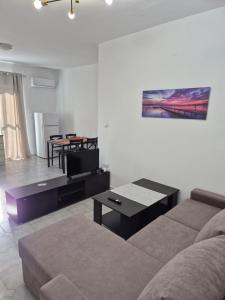 a living room with a couch and a table at Deco Apartments Aigina in Vaia