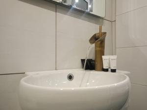 un lavabo blanc dans une salle de bain avec un miroir dans l'établissement Artemis Luxus Home and Spa Alexandroupolis City Faros, à Alexandroúpolis 14 autres photos