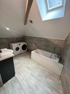 a bathroom with a tub and a washing machine at Appartement au centre in Charleville-Mézières