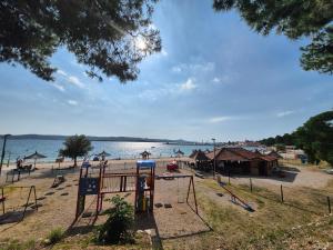a playground on a beach with a body of water at Mobile home San Antonio in Sveti Filip i Jakov