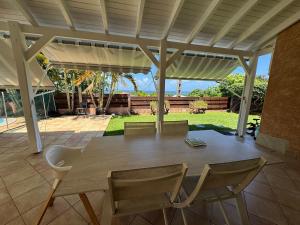 a wooden table and chairs on a patio at Villa Morne-Bou in Petit-Bourg