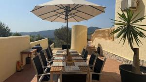 ハロンにあるVilla Almazaraのパティオにある傘付きの長いテーブル