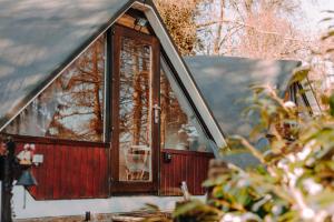 a window of a house with a dog in it at Chambre avec jacuzzi ou Chalets dans les bois in Gesves