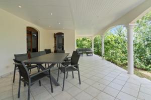 un patio extérieur avec une table et des chaises dans l'établissement Villa Diamantina, au Diamant