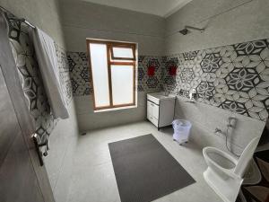 a bathroom with a toilet and a sink and a window at Skyline Homestay in Leh