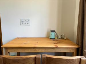 a wooden table with a coffee pot on top of it at Skyline Homestay in Leh