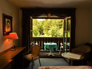 シェーナウ・アム・ケーニッヒスゼーにあるホテル ケーニッヒスゼー ホフの窓とテーブル付きのベッドルーム1室が備わる客室です。