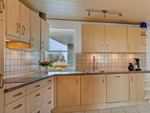 a kitchen with wooden cabinets and a window at Very Nice villa in Rødby in Rødby