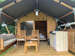 a tent with chairs and a couch and a table at Romala's Mini Glamp in Kiel +6 photos
