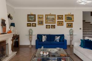 a living room with a blue couch and a fireplace at Villa in Sesimbra Pool Tennis Breakfast in Sesimbra