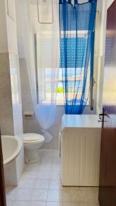 a bathroom with a tub and a toilet and a window at Casa Sea view Blu Marettimo in Marettimo