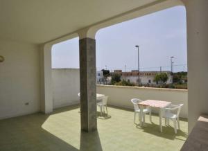 a patio with a table and chairs on a balcony at Gallipoli Mancaversa Futura Vacanza Andrea in Marina di Mancaversa