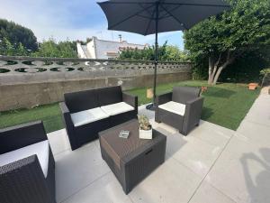 a patio with two chairs and a table with an umbrella at Villa Amaryllis in Pulsano