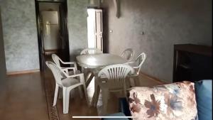 a dining room with a white table and chairs at Appartement Charmant et familiale in Saidia  +7 photos