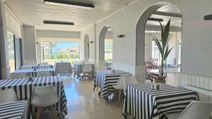 a restaurant with blue and white striped tables and chairs at Hotel Miramar Playa America Nigran in Nigrán