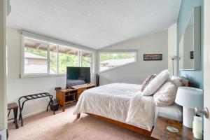 ein Schlafzimmer mit einem Bett und einem Fernseher und Fenstern in der Unterkunft Mt Hood Village Condo - Cozy Retreat with Fireplace in Mount Hood Village