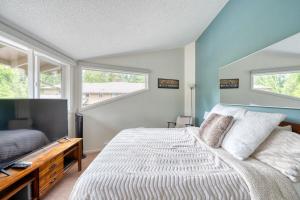 ein Schlafzimmer mit einem Bett und zwei Fenstern in der Unterkunft Mt Hood Village Condo - Cozy Retreat with Fireplace in Mount Hood Village + 15 Fotos
