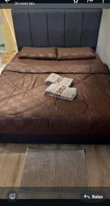 a brown bed with two towels on top of it at DAYANG HOMESTAy in Semporna