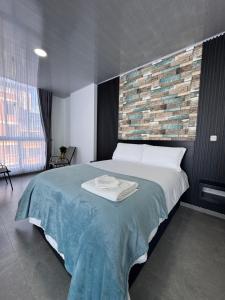 a bedroom with a large bed and a brick wall at Sky Suite in Sogamoso